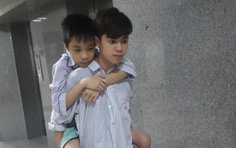 Đau lòng cảnh hai anh em mồ côi cha cõng nhau đi viện