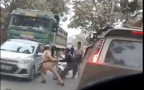 Cảnh sát giao thông bị hai người lạ cản trở cho xe vi phạm chạy thoát