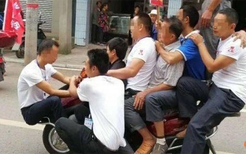 Chủ cửa hàng chở cùng lúc 9 người trên xe máy để quảng cáo