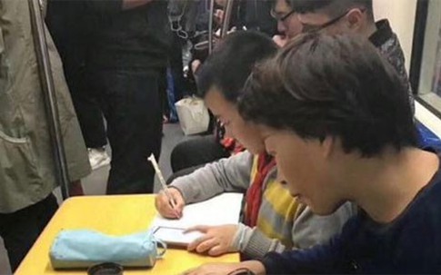 Mẹ kê bàn cho con làm bài tập trên tàu điện ngầm