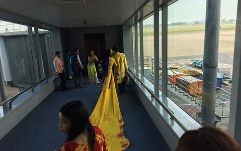 Vợ MC Thanh Bạch diện áo dài như đuôi công lên máy bay khiến nhiều hành khách choáng