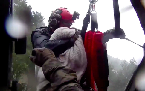 Trực thăng kéo nhân viên cứu hộ khỏi dòng lũ, dân mạng rớt nước mắt với thứ mà ông ôm chặt