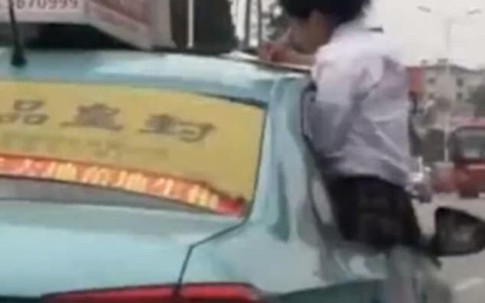 Nữ sinh làm bài tập trên nóc taxi đang chạy