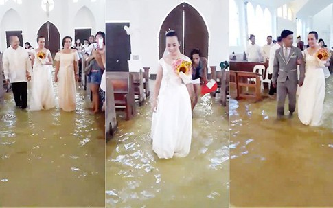 Cô dâu vén váy lội nước làm lễ cưới trong nhà thờ ngập lụt