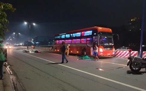 Chạy xe máy song song, 2 người bạn mắc tay lái ngã ra đường, 1 người bị xe khách cán chết
