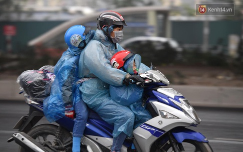 Trẻ nhỏ trùm chăn, khoác áo mưa chật vật theo chân bố mẹ rời Thủ đô về quê ăn Tết