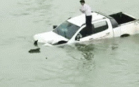 Hình ảnh tài xế trèo lên nóc xe ô tô trôi lềnh bềnh giữa sông khiến nhiều người hoang mang