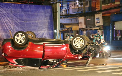 TP.HCM: Ô tô húc văng cột đèn rồi lật ngửa, 2 người bò ra khỏi xe kêu cứu