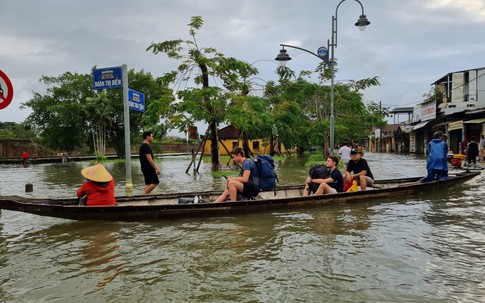 Ảnh: Du khách ngồi ghe qua đường ngập lụt, người dân cất vó bắt cá bên kinh thành Huế