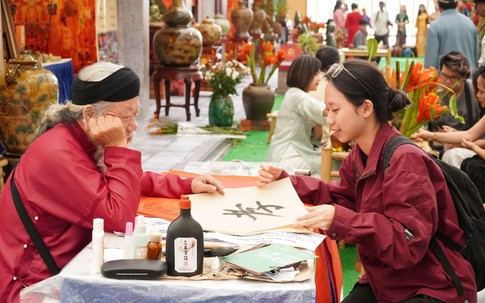 Du khách thích thú với trải nghiệm xin chữ, tự viết thư pháp tại Hội chợ Mùa Thu 2025