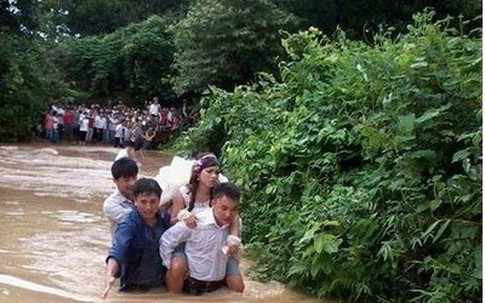 Bức ảnh chú rể cõng cô dâu trong nước lũ gây xúc động